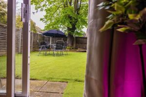 a patio with a table and chairs and an umbrella at Pristine Relocation House in London