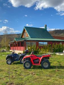 two atvs parked in a field in front of a house at Vila Montenegro Piva consists of two units Lux apartment and Central part of the house in Plužine