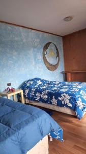 a bedroom with two beds and a painting on the wall at marari rapa nui in Hanga Roa
