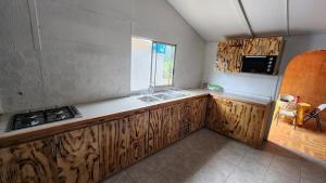 a kitchen with wooden cabinets and a sink in it at marari rapa nui in Hanga Roa