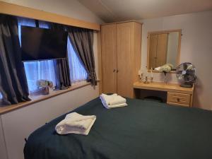 a bedroom with a green bed and a window at Vacation Escape - Valley Farm -Clacton-on-sea - Holiday Park in Clacton-on-Sea