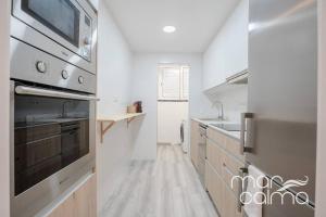 een keuken met een wastafel en een fornuis top oven bij Apartamento Miramar by MarCalma in Torredembarra
