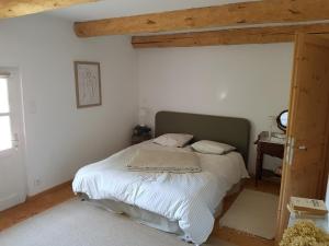 a bedroom with a bed with white sheets at Les Fonts de Baix in Plan-de-Baix