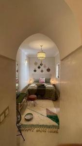 a room with a bed and a living room with a table at Dar Vevé - Design, style & relax in Dar el Bacha in Marrakesh