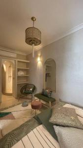 a bedroom with a bed and a chair and a chandelier at Dar Vevé - Design, style & relax in Dar el Bacha in Marrakesh