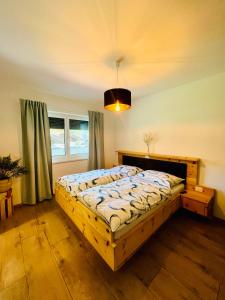 sypialnia z drewnianym łóżkiem w pokoju w obiekcie Reizender Bungalow - mit 120qm - in ruhiger Lage w mieście Hermagor