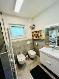 łazienka z umywalką, toaletą i oknem w obiekcie Reizender Bungalow - mit 120qm - in ruhiger Lage w mieście Hermagor