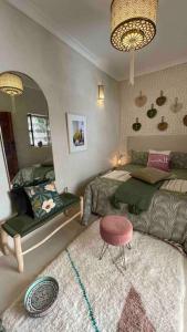 een slaapkamer met een bed, een spiegel en een kruk bij Dar Vevé - Design, style & relax in Dar el Bacha in Marrakesh