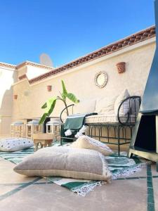 a patio with pillows on the floor of a house at Dar Vevé - Design, style & relax in Dar el Bacha in Marrakesh