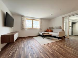 a living room with a couch and a tv at Ferienwohnung Hingucker in Tschagguns