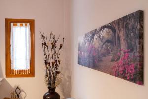um quarto com uma pintura na parede e um vaso com flores em Norma’s House em Khlóï