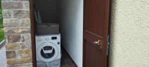 una lavadora y secadora en una habitación junto a una puerta en La Quagnola splendida casa in Appennino, en Polinago