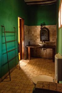 a bathroom with a sink and a green wall at PASHA HOTEL Zanzibar in Nungwi