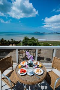 a table with food on a balcony with a view of the beach at Nobile Suites Diamond in Vitória