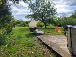 un banco del parque con un barco en el césped en Un petit coin de paradis, 