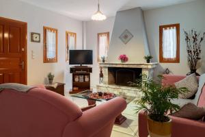 ein Wohnzimmer mit rosa Stühlen und einem Kamin in der Unterkunft Norma’s House in Khlóï