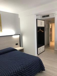 a bedroom with a blue bed and a kitchen at Alloggi Pontecorvo Liviana in Padova