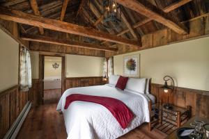 a bedroom with a large bed with wooden ceilings at Christmas Farm Inn and Spa in Jackson
