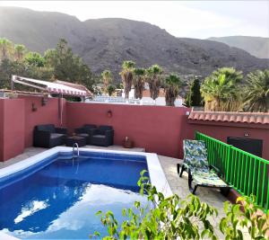 una piscina en la azotea de una casa con montañas en el fondo en Candelaria Estudio1-Garoé, en Candelaria