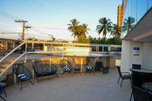 a balcony with chairs and a table and a boat at Nobile Suites Diamond in Vitória