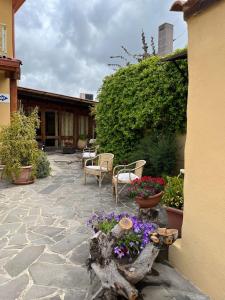 un patio con sillas y flores en Agriturismo la Cantina, en Baratili San Pietro