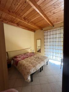 1 dormitorio con cama y techo de madera en Agriturismo la Cantina, en Baratili San Pietro