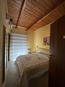 Un dormitorio con una cama grande y una ventana en Agriturismo la Cantina, en Baratili San Pietro