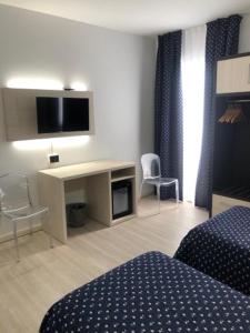 a hotel room with a bed and a desk with a television at Alloggi Pontecorvo Liviana in Padova