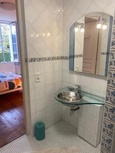 La salle de bains est pourvue d'un lavabo et d'un miroir. dans l'établissement Chambre Les Deux Chênes près de Bergerac, à Le Fleix