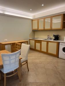 a kitchen with wooden cabinets and a table and chairs at Santa Marina Apartment 503 in Sozopol