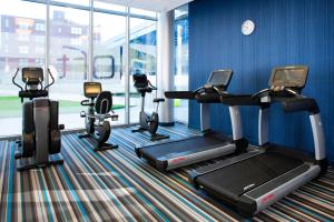 un gimnasio con equipo cardiovascular en una sala con paredes azules en Aloft Cleveland Downtown, en Cleveland