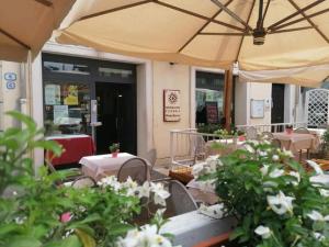 un patio con tavoli, sedie e ombrellone di Alloggi Pontecorvo Liviana a Padova