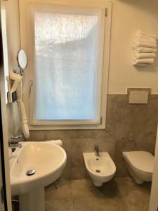 a bathroom with a sink and a toilet and a window at Alloggi Pontecorvo Liviana in Padova