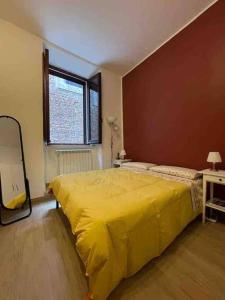 Un dormitorio con una cama amarilla y una ventana en Appartamento nel Borgo, en Orte