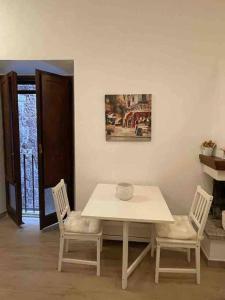 - une table et deux chaises dans le salon dans l'établissement Appartamento nel Borgo, à Orte