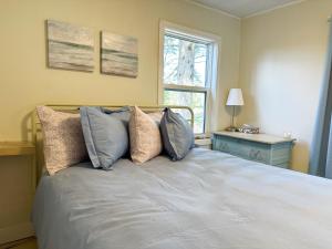 a bedroom with a bed with pillows and a window at Peaceful Lily Pad Cottage In Hubbards in Hubbards