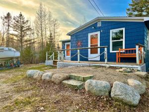 a blue tiny house with rocks in front of it at Peaceful Lily Pad Cottage In Hubbards in Hubbards