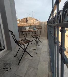 un patio con tavolo e sedie sul balcone. di white caves catania rooms a Catania