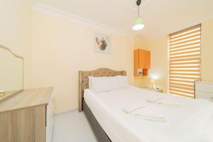 een slaapkamer met een groot wit bed en een raam bij Flat in Antalya