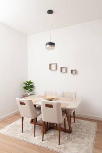 uma sala de jantar com uma mesa branca e cadeiras brancas em Apartamento una habitación DLX em Echeverría