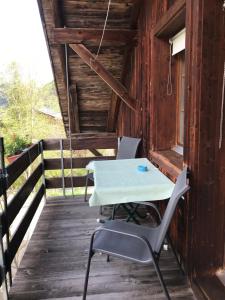 einen Tisch und Stühle auf der Veranda einer Hütte in der Unterkunft bundb-wyssen-matten in Matten