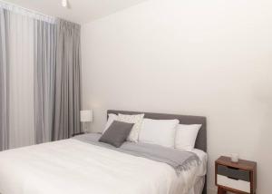 um quarto branco com uma cama grande e almofadas brancas em Apartamento una habitación DLX em Echeverría