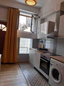 cocina con fogones, fregadero y ventana en 40 sqm 1 bedroom next to Paris/Disney, en Joinville-le-Pont