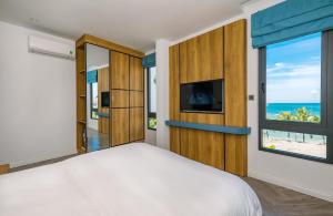 Schlafzimmer mit einem Bett und Meerblick in der Unterkunft Cát Lợi Phú Quốc Hotel in Phu Quoc