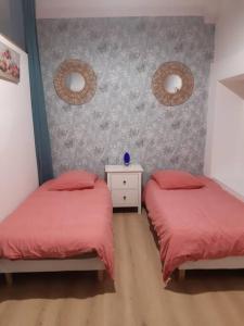 1 dormitorio con 2 camas con sábanas rojas y pared en 40 sqm 1 bedroom next to Paris/Disney, en Joinville-le-Pont