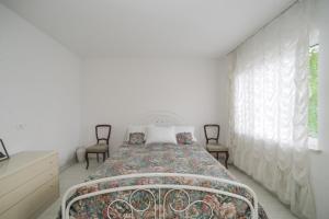 1 dormitorio blanco con 1 cama y 2 sillas en Cvrkut Ptica - Mladenovac, en Mladenovac