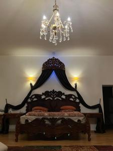 a bedroom with a bed with a chandelier at Apartamentai Lampėdžiuose in Kaunas