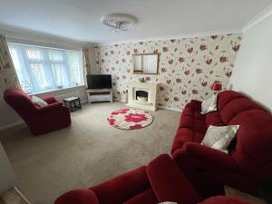 sala de estar con sofá rojo y chimenea en Redd Lodge Heart of the National Forest en Thringstone