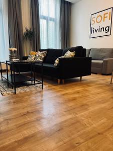 a living room with a black couch and a table at SOFI living in Ostrava