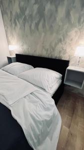 a bed with white sheets and pillows in a bedroom at SOFI living in Ostrava